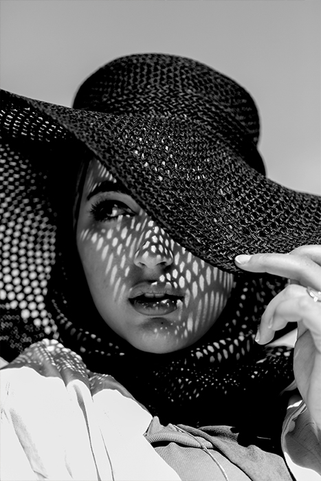 Retrat en blanc i negre d’una noia jove amb un barret