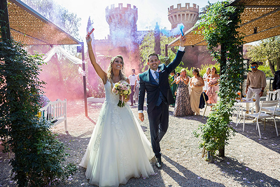 Parella de nuvis celebrant el seu casament al Castell de Peralada passejant pel pati.
